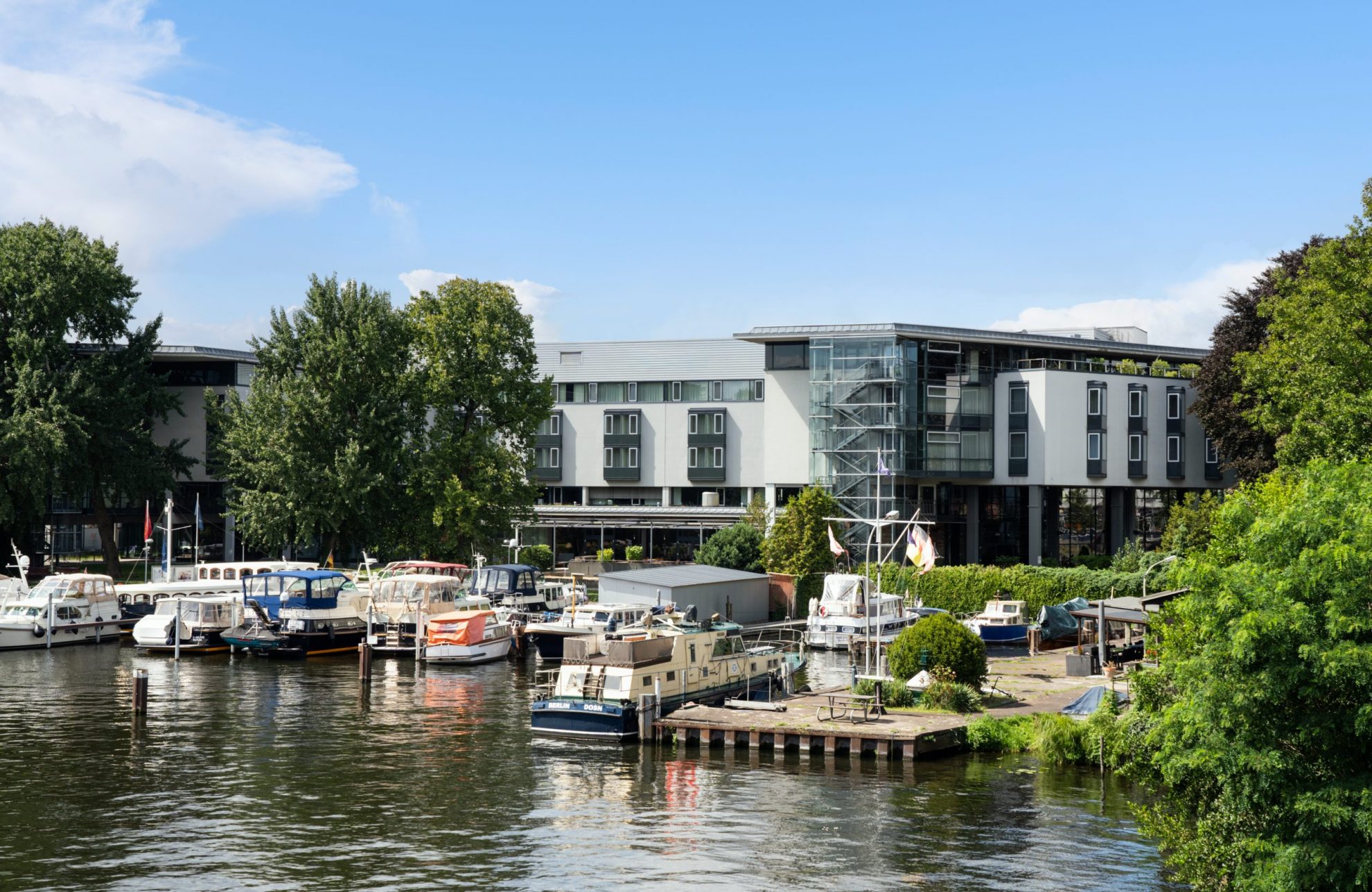 Hotelansicht am Wasser mit Schiffen im Vordergrund