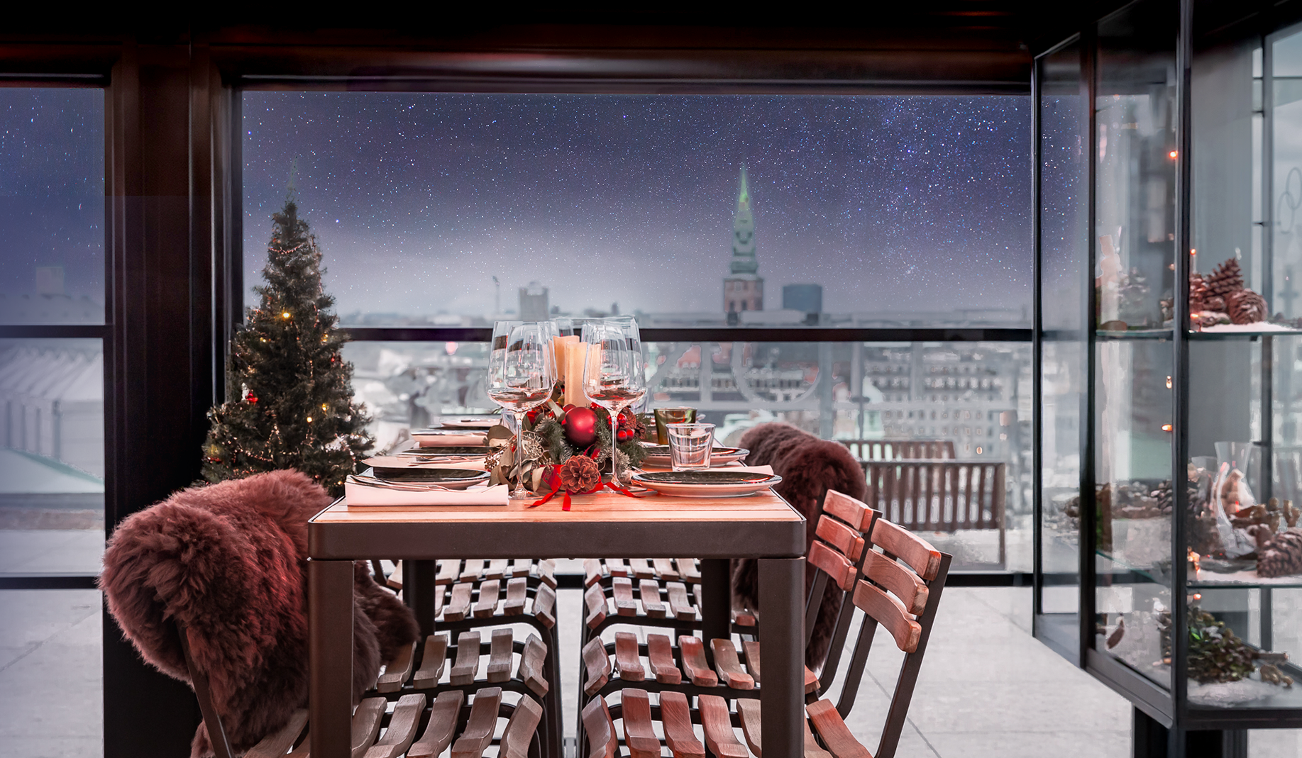 weihnachtlich gedeckter Tisch vor großem Fenster mit Ausblick Skyline