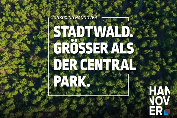 H Werbeplakat der Kampagne „Unboxing Hannover“. Eine Luftaufnahme eines dichten grünen Waldes dient als Hintergrund. In einem weißen Rahmen steht der Text: „STADTWALD. GRÖSSER ALS DER CENTRAL PARK.“ Unten rechts befindet sich das Logo der Stadt Hannover.