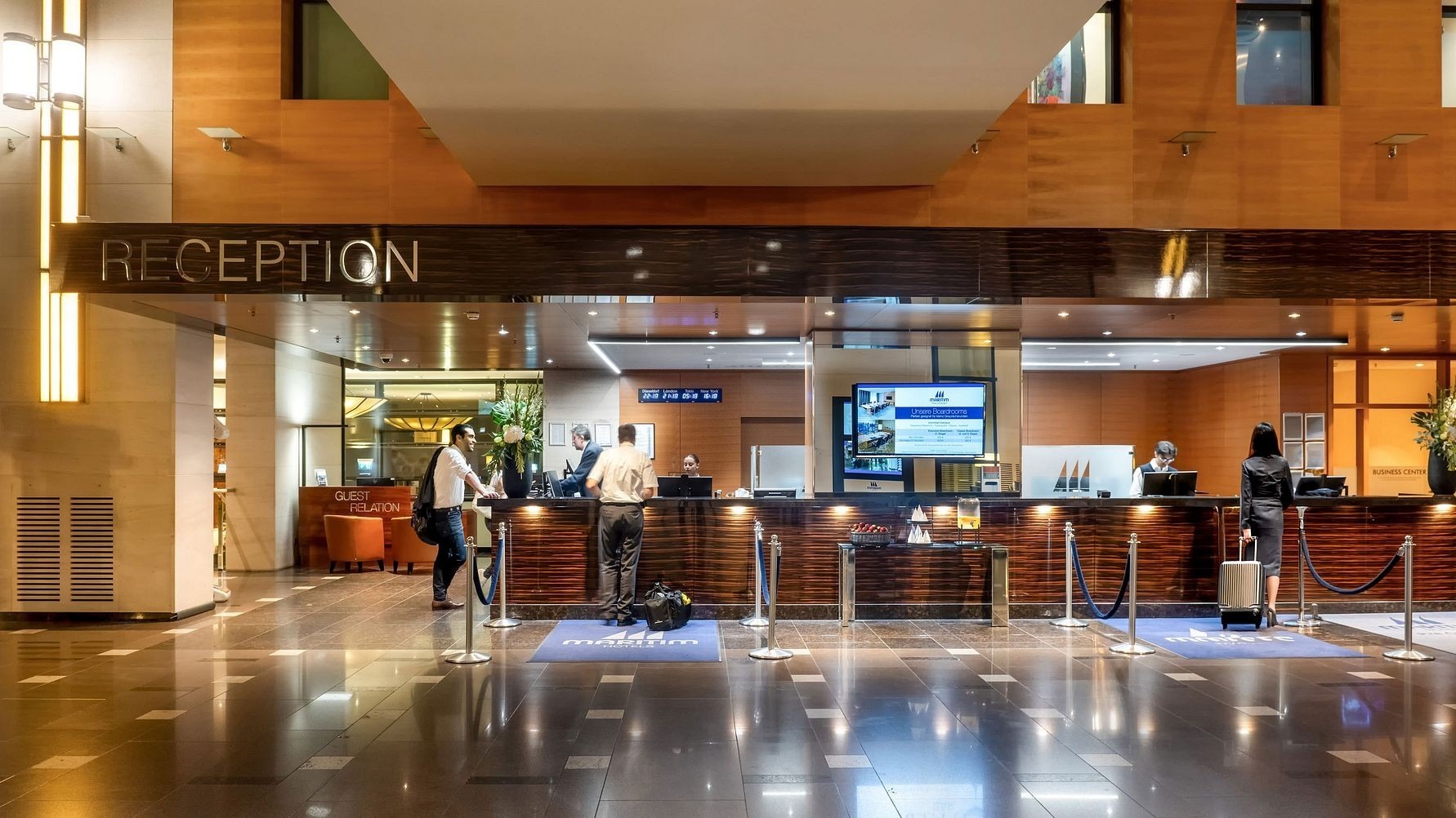 Blick auf moderne Hotelrezeption und Personen die einchecken