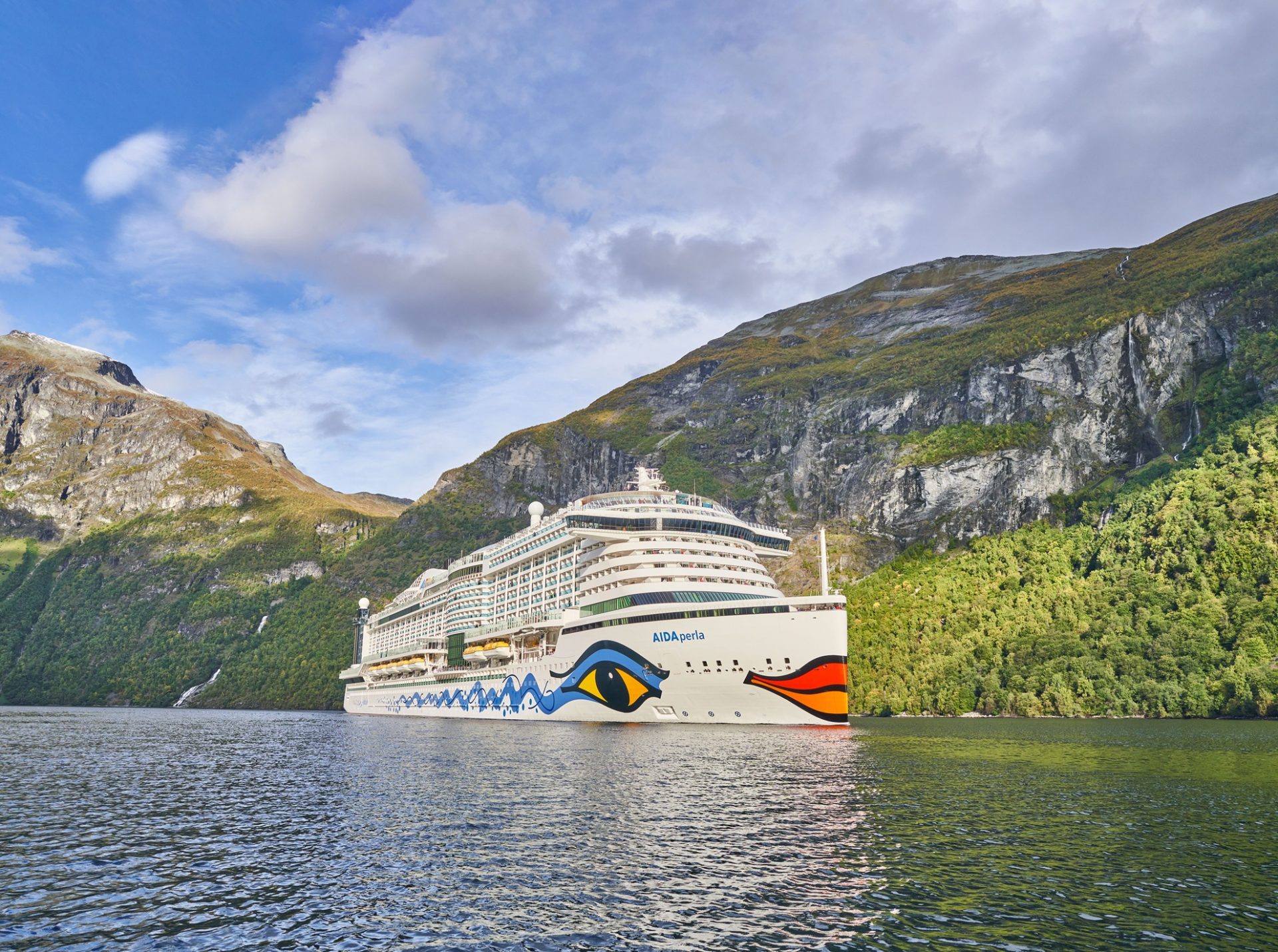 Blick auf AIDA-Schiff im Vordergrund Wasser und im Hintergrund Berge