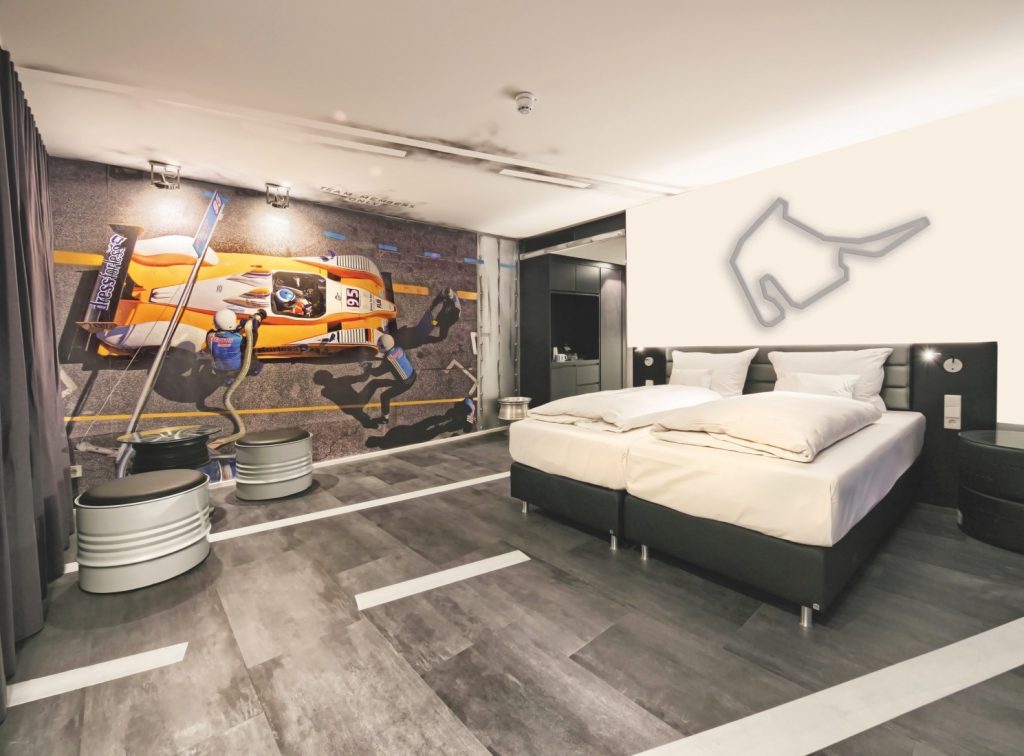 Blick in Hotelzimmer mit großem Poster von Rennwagen